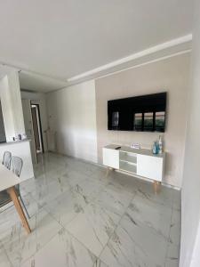 uma sala de estar com televisão e piso em mármore em Casa SoSò em Massa