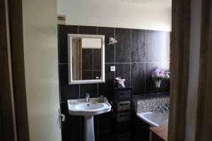 ein Bad mit einem Waschbecken und einem Spiegel in der Unterkunft Appartement dernier étage vue imprenable sur mer in Bastia