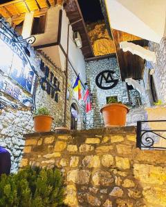 a stone wall with potted plants on top of it at Guva Mangalem Hotel Restaurant in Berat