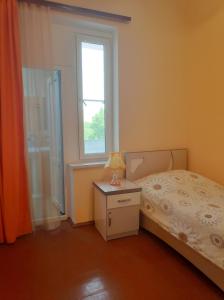 Schlafzimmer mit einem Bett und einem Fenster in der Unterkunft Happy house in Chʼiva