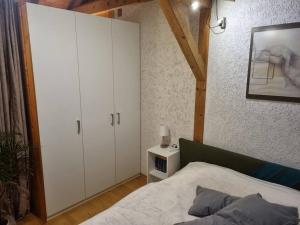 um quarto com uma cama e um armário branco em Gemütliche Dachgeschosswohnung em Erfurt