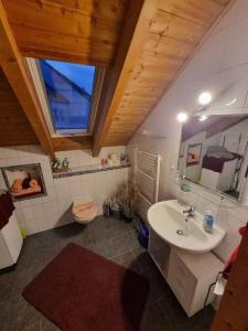 uma casa de banho com um lavatório, um WC e um espelho. em Gemütliche Dachgeschosswohnung em Erfurt