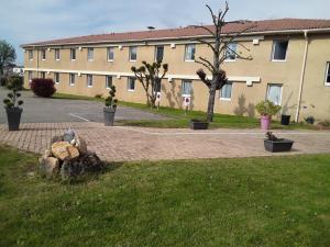 un bâtiment avec un parc avec un rocher dans l'herbe dans l'établissement Contact Hôtel ALYS Bourg en Bresse Ekinox Parc Expo, à Bourg-en-Bresse
