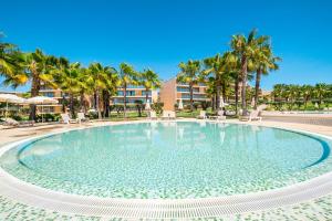 a large pool with palm trees in a resort at Apartment Salgados by Algarve Vacation in Albufeira