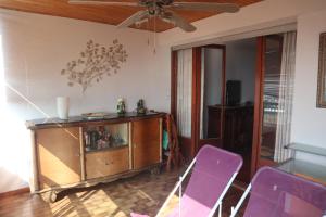ein Wohnzimmer mit lila Stühlen und ein Entertainment-Center in der Unterkunft Appartement dernier étage vue imprenable sur mer in Bastia