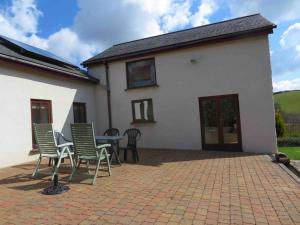 a patio with chairs and a table in front of a house at Creedy Meadow Barn in Crediton