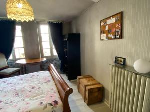 a bedroom with a bed and a table and windows at Appartement calme centre ville in Ussel