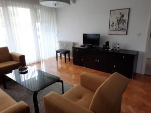 a living room with a couch and a tv and a table at Apartment Majatalo in Zagreb