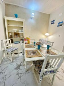 a dining room with a white table and chairs at Ortigia Dreaming in Siracusa