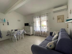 uma sala de estar com um sofá e uma mesa em Case del Mar em Santa Teresa Gallura