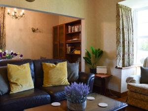 a living room with a leather couch with yellow pillows at Hillview in Crooklands