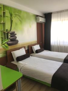 a room with two beds and a green wall at Hotel GabriSa in Razgrad