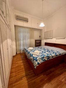 a bedroom with a bed in a room with wooden floors at Vintage-style 2 bedroom apartment at Katechaki in Athens