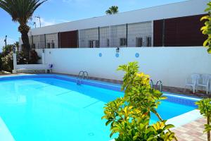 a swimming pool in front of a building at Fantastic vacation by the ocean in Playa de las Americas