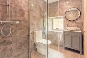 a bathroom with a toilet and a glass shower at Hayes Farm - 8 Houses in Gloucester