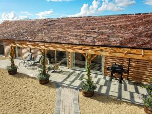 a house with a wooden roof and a patio at Hayes Farm - 8 Houses in Gloucester