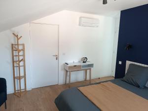 a bedroom with a bed and a desk with a sink at A l'Ombre des Bois, Chambre double vue jardin in Neung-sur-Beuvron