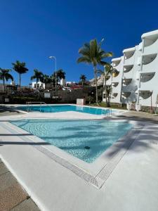 una piscina in un resort con palme di El Cardenal a Playa del Cura