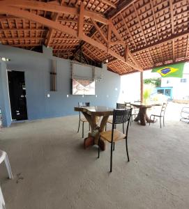 Habitación con mesas, sillas y techo de madera. en POUSADA ALÉM-K en Riachão