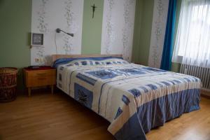 a bedroom with a bed with a blue and white comforter at Urlaub mit verglaster Terrasse in Emmingen-Liptingen