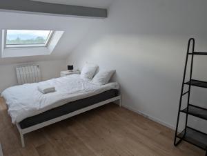um quarto com uma cama com lençóis brancos e uma janela em Le Vauban - appartement 2 chambres, salon, cuisine équipée, parking et wifi gratuit em Mulhouse