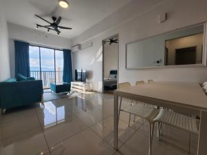 uma sala de estar com uma mesa e cadeiras e uma ventoinha de tecto em Praicon Executive Suite em Butterworth