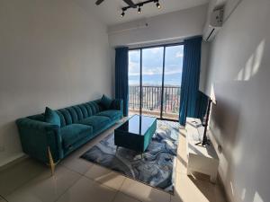 a living room with a green couch and a large window at Praicon Executive Suite in Butterworth