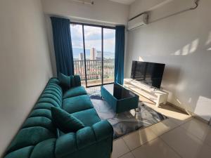 a living room with a green couch and a large window at Praicon Executive Suite in Butterworth