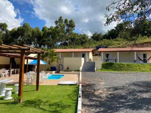 een villa met een zwembad en een huis bij Pousada Saint James in Águas de Lindóia