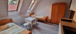 ポビエロボにあるPod Żaglamiのベッド、テーブル、椅子が備わる小さな客室です。