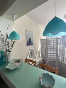 two blue pendant lights hanging over a green table at Farniente Tolo in Tolo +9 photos