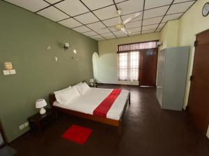 una camera con un letto in una stanza con pareti verdi di Oasis Colombo a Colombo