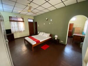 a bedroom with a bed with a red blanket at Oasis Colombo in Colombo