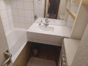 a bathroom with a sink and a tub and a toilet at appartement au pied des pistes in Valmorel