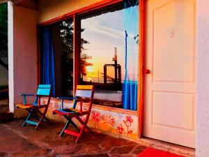 two chairs sitting in front of a window at Playa del Ritmo Beach Hostel & Bar in Santa Marta