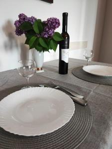 a table with a white plate and a bottle of wine at Jasmina in Senj