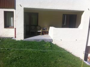 a white building with a patio with a chair in it at appartement au pied des pistes in Valmorel