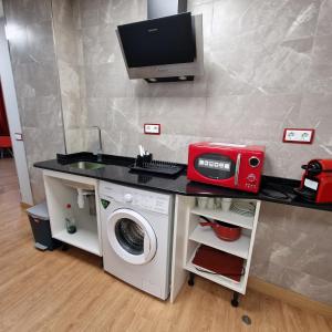 a kitchen with a washing machine and a computer on a counter at Gavilanes 2 TOLEDO in Toledo