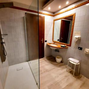 a bathroom with a shower and a sink and a mirror at Hotel Bellavista in Abetone