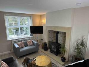 a living room with a couch and a fireplace at Impressive 3 bed cottage by the river in Stanhope in Stanhope
