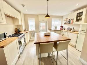 a kitchen with a wooden table and white cabinets at Impressive 3 bed cottage by the river in Stanhope in Stanhope