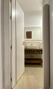 a white bathroom with a sink and a mirror at Casa Buitreras in El Colmenar