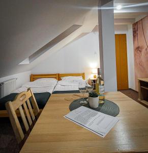um quarto com uma mesa com uma cama e copos de vinho em Willa Centrum em Supraśl