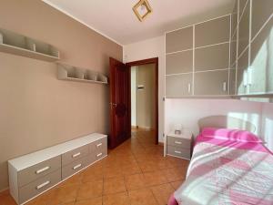 a bedroom with a bed with pink sheets and cabinets at Tetto Verde in Carolei