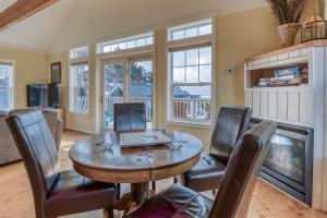 a dining room with a table with chairs and a laptop at Driftwood at Roads End in Lincoln City