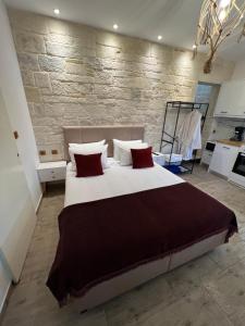 ein Schlafzimmer mit einem großen Bett mit roten Kissen in der Unterkunft CARA Creta Beach House in Kolimvárion