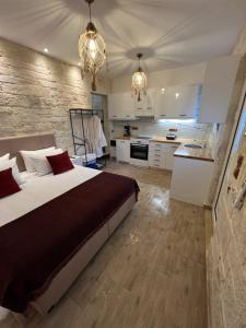 a bedroom with a large bed and a kitchen at CARA Creta Beach House in Kolymvari