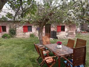 drewniany stół z krzesłami i stół z kwiatami w obiekcie "Descanso en Babia " VUT-LE-483 w mieście Torrebarrio