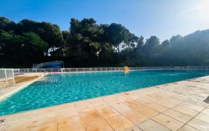 锡富尔勒普拉日Domaine de La Coudouliere, Vue Mer, Plage, Piscine et Parc的水中人的大型游泳池