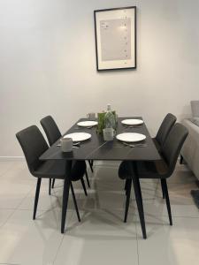 a black dining room table with black chairs at Chambers Suites KL in Kuala Lumpur